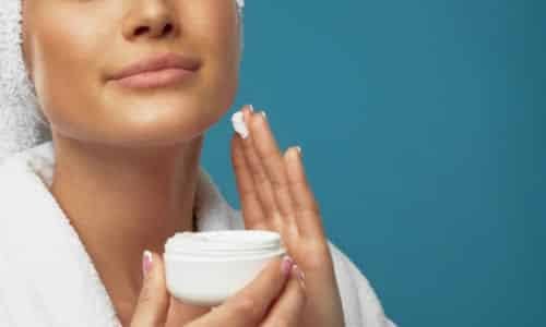 Donna si spalma un tonico sul viso per la sua skincare quotidiana