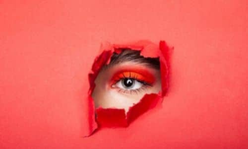 occhio che si scorge da una parete rossa